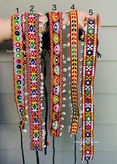 a person holding several colorful bracelets in their hands with numbers on the side of them