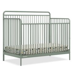 a baby crib with white sheets on the bottom and side rails, in grey