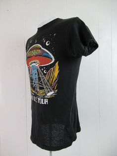 "Vintage 1970s black cotton rock and roll band concert tour t shirt with multi color glitter graphics. Front has a UFO and Boston 1979 U.S. Tour. Back has band members. Size small. Actual measurements are: 35\" around the chest 35\" around the waist 15\" shoulder seam to shoulder seam 27\" overall length In excellent condition." Relaxed Fit Screen Print Tops For Music Festivals, Cotton Grunge Tops For Music Festivals, Grunge Tops With Screen Print For Music Festivals, Fitted Concert T-shirt With Graphic Print, Fitted Graphic Print T-shirt For Concert, Cotton Crew Neck Tops For Music Festivals, Black Cotton Top For Music Festivals, Relaxed Fit Band Merch Top For Music Festivals, Fitted Graphic Print T-shirt For Festival