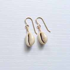 Simple & cute describe these whole cowrie shell earrings! They're the perfect accessory to wear with your favorite casual outfit when you're out & about. Please allow for variations in size and shape of shells as each is unique. Casual Shell Jewelry Gift, Handmade Cowrie Shell Earrings For Gift, Handmade Cowrie Shell Earrings As Gift, Casual Cowrie Shell-shaped Jewelry, Handmade Casual Shell Jewelry, Casual Handmade Shell Jewelry, Cowrie Shell Dangle Earrings As Gift, Gold Cowrie Shell Earrings For Gift, Gold Cowrie Shell Earrings As Gift