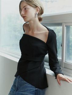 This product is a Square Neck Tulip Blouse that combines a structured square neckline with the soft, flowing lines of a tulip-shaped body, offering a blend of geometric and organic design elements. The blouse features a fitted waist that accentuates the silhouette, while the peplum detail adds a touch of drama and femininity to the overall aesthetic. Crafted to provide a sophisticated and polished look, this piece is perfect for both formal and casual settings. - The blouse boasts a square neckline that frames the collarbones and lends a modern edge.- A peplum waist creates a flattering tulip-like silhouette that enhances the garment's elegance.- The long sleeves add a traditional touch, balancing the contemporary neckline and fitted bodice.- Constructed with a blend of materials that Elegant Structured Blouse For Work, Formal Off-shoulder Tops For Fall, Elegant Structured Evening Tops, Modern Fall Blouse For Night Out, Fitted Top With Asymmetrical Neckline For Workwear, Modern Blouse For Fall Night Out, Modern Blouse For Night Out In Fall, Chic Structured Party Tops, Chic Structured Formal Tops