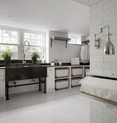 a kitchen with white tile and stainless steel fixtures, including sink, counter tops, and cabinets