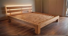 a wooden bed frame sitting on top of a hard wood floor next to a sliding glass door