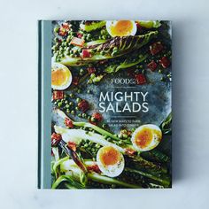 a cookbook with an image of vegetables and eggs on it, sitting on a white surface