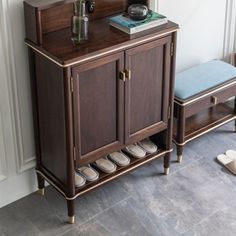 a wooden cabinet with shoes on it next to a wall