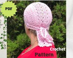 a woman wearing a pink crochet hat with a bow on her head and green leaves in the background