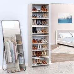 a white closet filled with lots of shoes next to a large mirror and a bed