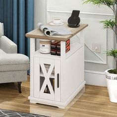 a small white end table with a phone on top