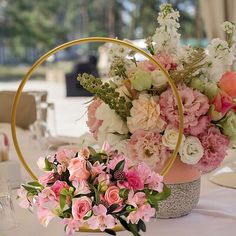 a table topped with a basket filled with pink and white flowers on top of it