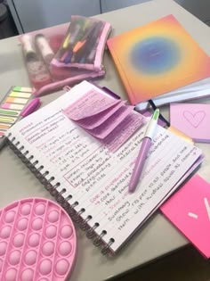 several notebooks and pens are sitting on a table with other stationery items around them