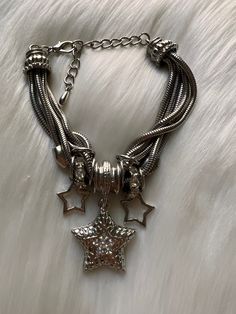 Exactly vintage condition. One large star with faux diamonds, two smaller stars and two faux diamond rings. Lobster claw closure. Measures at 10 inches long. Star-shaped Metal Jewelry With Lobster Clasp, Star Shaped Metal Jewelry With Star Charm, Star Shaped Metal Jewelry With Lobster Clasp, Metal Star Charm Jewelry, Silver Stainless Steel Jewelry With Star Charm, Star Jewelry With Lobster Clasp, Metal Star Charm Jewelry For Party, Metal Star-shaped Bracelets, Adjustable Dangle Jewelry With Star Charm