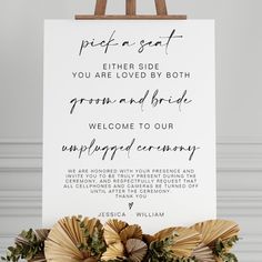 an easel holding a sign that says, pick a seat either side you are loved by both groom and bride welcome to our unplugged ceremony