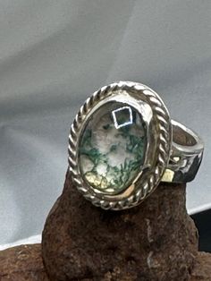 Set yourself apart wearing this unique artistic sterling silver green agate ring. This silver ring has a beautiful agate stone set atop a heavy band. * Sterling Silver (925) * 6.5 ring size * 11.8 grams total weight This is a completely custom design, made entirely by Michael Presley from concept to completion.  Michael's personal style reflects commitment to quality and the creation of unique, wearable works of art. In addition to pieces you find on Etsy, Michael's specialty is personalized design, which includes meeting with the client, and keeping in touch throughout the journey of the design. Silver Moss Agate Ring With Natural Inclusions, Unique Oval Emerald Ring In Sterling Silver, Unique Moss Agate Rings For Anniversary, Handmade Oval Moss Agate Ring, Unique Chrysocolla Rings As Gift, Unique Chrysocolla Rings For Gift, Handmade Silver Moss Agate Rings, Handmade Silver Rings With Moss Agate, Green Moss Agate Oval Jewelry