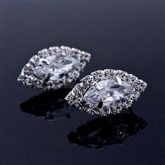 pair of diamond earrings on black surface