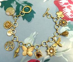 Beautiful vintage inspired bracelet with 12 plant and insect brass charms on a  brass round link chain. The charms are all 3d and include a real dried flower, a vintage enamel flower, rhinestones and coloured glass cabochon to add interest and extra detail.  The bracelet is a lovely golden colour which has been polished and coated in a protective wax but as with all brass jewellery it will darken with time but can be repolished or left to form a natural patina as desired. The bracelet will be supplied in a velvet gift pouch. Eclectic Gold Jewelry Gift, Bohemian Gold Charm Bracelet With Lobster Clasp, Gold Bohemian Charm Bracelet With Lobster Clasp, Gold Bohemian Charm Bracelet Nickel Free, Bohemian Gold Brass Charm Bracelet, Bohemian Gold Charm Bracelet In Brass, Bohemian Antique Gold Charms Jewelry, Eclectic Gold Jewelry For Jewelry Making, Gold Bohemian Bracelets With Charms