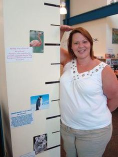 a woman standing next to a refrigerator with magnets on it