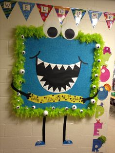 a bulletin board decorated with green grass and monster eyes