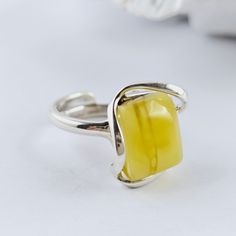 Unique Natural Baltic Amber Ring, White yellow Amber Ring, Amber And Sterling Silver Ring, Baltic Amber Jewelry, Amber Gift For Her, White yellow Amber Amazing adjustable ring made of natural Baltic amber and sterling silver. White Baltic Amber ring. Really stunning, Baltic amber ring in a beautiful white and yellow color. This handmade ring is made of 100% natural, polished Baltic amber and sterling silver. Weight: 7,43 g Dimensions: approx. 1,8 x 1,7 x 1 cm / 0.70 x 0.66 x 0.39 inch Size: adjustable Sterling silver 925 It's a handmade product, each item is unique. Great as a gift. Each of our products is packed in a beautiful gift box. Baltic amber manufacturer and seller from Poland. Our jewelry, beads and other goods shop: https://www.etsy.com/shop/FineBalticJewelry Shipping time to yo Yellow Adjustable Open Ring Jewelry, Adjustable Yellow Open Ring Jewelry, Minimalist Yellow Sterling Silver Jewelry, Yellow Citrine Rectangular Rings, Adjustable Yellow Rings Suitable For Gifts, Adjustable Yellow Rings As Gift, Yellow Open Ring Jewelry For Anniversary, Adjustable Yellow Rings For Gift, Yellow Rectangular Citrine Ring