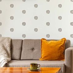 a living room with a couch, coffee table and wallpaper on the walls behind it