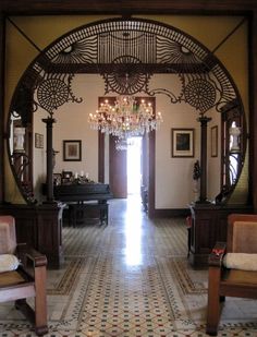 an ornate entry way with chandelier and chairs