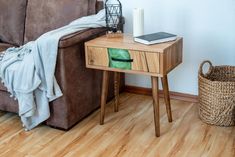 a brown couch sitting next to a wooden table on top of a hard wood floor