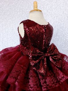 A modern country-inspired dress with cascading ruffle tiers carefully hand stitched to perfection for any upscale event or birthday! The burgundy sequin sleeveless bodice is fully lined for the ultimate comfort. Beautiful embroidery can be found across the waistline for added detail. The dress comes with a detachable sequence bow. Zipper can be found on the back of the dress. The skirt is made out of multiple rows of tulle ruffles with lace hem with four layers of tulle used on each row for a un Festive Sleeveless Princess Dress For Wedding, Sleeveless Princess Dress For Wedding And Festive Occasions, Festive Sleeveless Wedding Princess Dress, Holiday Princess Dress With Ruffles For Dress-up, Holiday Ruffled Princess Dress For Dress-up, Christmas Fitted Gown For Dress-up, Elegant Sleeveless Princess Dress For Festive Occasions, Sleeveless Holiday Princess Dress For Festive Occasions, Holiday Sleeveless Princess Dress With Ruffles