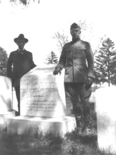 two men standing next to each other near a monument