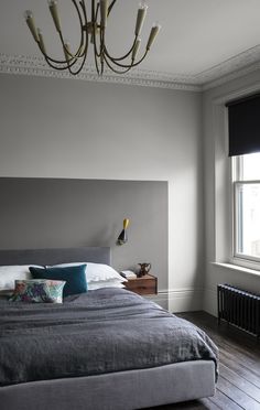 a bedroom with gray walls and wooden floors