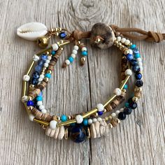 Embrace the spirit of nature and tradition with this Handmade Multi-Strand Bracelet, a unique blend of cultural symbolism and artisanal craftsmanship. Featuring a combination of natural stones like white turquoise, bohemian crystals, and coconut beads, this bracelet brings together elements that tell a story of connection to the earth and sea. Hand-threaded on a durable suede cord, the design is finished with an elegant handmade ceramic button and adorned with a cowrie shell, evoking ancient mea Bohemian Adjustable Wrap Bracelet With Gemstone Beads, Bohemian Braided Bracelets With Round Beads For Healing, Bohemian Gemstone Beads Friendship Bracelets, Bohemian Hand Wrapped Turquoise Braided Bracelets, Bohemian Multi-strand Hand-strung Bracelets, Bohemian Turquoise Hand Wrapped Braided Bracelets, Bohemian Turquoise Hand-wrapped Braided Bracelets, Bohemian Multi-strand Bracelets, Bohemian Turquoise Braided Bracelets