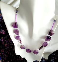 "This piece is titled \"Lavender Dreams\", featuring several stunning genuine amethyst gemstones in a beautiful shade of lavender. The amethyst gemstones are expertly cut and polished to showcase their natural beauty and shine, and small faceted glass beads lie between along a high-quality nylon-coated stainless steel wire. The necklace measures 16 to 19 inches in length, and the closure is a silver-plated lobster claw and has a tiger tail left for adjustment. It's the perfect length to wear with a variety of necklines. Please contact CraftsRU if you need it longer - we handmake our crafts and are happy to accommodate within reason. I hope you will love this piece as much as I do, and as always, thanks for considering this handmade craft from CraftsRU." Lavender Handmade Necklace, Tiger Tails, Tiger Tail, A Tiger, Wedding Jewellery Necklace, Stainless Steel Wire, Amethyst Necklace, Faceted Glass, Amethyst Gemstone