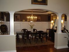 the dining room table is set for six with black chairs and white wains on the wall