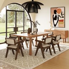 a dining room table and chairs in front of a large window with an art work on the wall