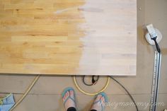 a person standing next to a piece of wood on top of a hard wood floor