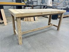 a table made out of wood sitting in a garage next to other workbench