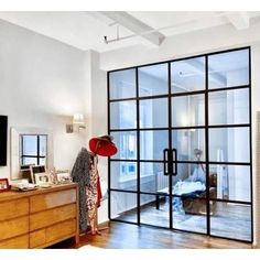 a person with a red hat standing in front of a sliding glass door that leads to a bedroom