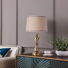 a living room scene with focus on the sideboard and lamp in the foreground