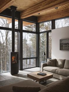 a living room filled with furniture and a fire place in front of a window covered wall