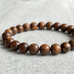 Features: ~ 6mm, 8mm or 10mm fragrant Tiger Skin Sandalwood beads ~ Strong, non-fraying elastic cord; simply slide bracelet on and off wrist ~ Comes packaged in a re-usable microfiber pouch ~ Avoid wearing in water as wood naturally fades if exposed to water To ensure the perfect fit, please use the bracelet sizing instructions found in the photo gallery. For more wood beaded bracelets please use the following link: https://www.etsy.com/ca/shop/FujiBeads?ref=shop_sugg&search_query=wood Be sure t Brown Wooden Beads Bracelet, Brown Stretch Bracelet With 8mm Round Beads, Brown Round Beads Bracelets For Meditation, Brown Round Beads Bracelet For Meditation, Brown Round Beads Meditation Bracelet, Brown Bracelets With 8mm Beads, Brown 8mm Beaded Round Bracelets, Brown Bracelet With 8mm Round Beads, Brown Round Bracelets With 8mm Beads