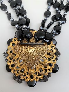 "A dramatic necklace & ear clip set by noted costume jewelry designer Lawrence Vrba, who worked for Miriam Haskell before launching his own line. The large scale pendant/brooch The large pendant can be removed from the necklace and worn as a brooch. The matching ear clips Four Strand, The necklace, brooch and the earrings are signed and made in USA In very good condition. Necklace 21\" long, Brooch 4\" - clip on earrings 1\" Pictures are part of the description so please look at all the pict Evening Brooch Pendant Necklaces, Pendant Necklaces With Brooch For Evening, Unique Evening Clip-on Jewelry, Costume Jewelry Brooch For Evening, Evening Costume Jewelry Brooch, Evening Clip-on Costume Jewelry, Ornate Clip-on Jewelry For Party, Formal Costume Jewelry Necklace With Brooch, Black Crystal Necklace