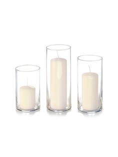 three clear glass candles are sitting in front of each other