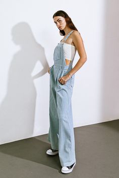 A sophisticated denim jumpsuit adorned with adjustable straps, a front center pocket, side button closure, pleated pants, back pockets, and wide legs.Details:Self : 100% CottonSize & Fit- Model is 5`8" And Wearing Size Small- Measurements Taken From Size Small- Approx. Length: 59" Chic Medium Wash Jumpsuits And Rompers With Pockets, Spring Overalls With Adjustable Straps, Chic Denim Blue Jumpsuits And Rompers With Pockets, Chic High Waist Cotton Overalls, Full-length Denim Blue Jumpsuit For Spring, Chic Overalls With Suspenders For Spring, Full-length Denim Jumpsuit For Spring Workwear, Chic Wide Leg Overalls For Work, Light Wash Denim Jumpsuit With Bib Front