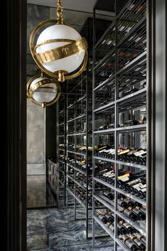 a wine cellar filled with lots of bottles next to a wall mounted light hanging from the ceiling