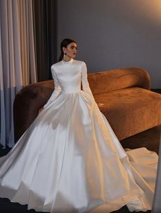 a woman in a white wedding dress sitting on a couch