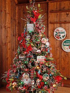 a decorated christmas tree in the corner of a room with wood paneled walls and wooden floors