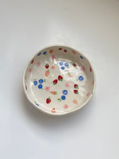 a white bowl with colorful flowers on it