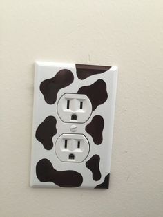 a white and black cow print light switch cover