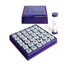 a blue and white box with letters on it next to a purple container filled with dices