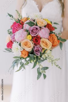 a woman in a white dress holding a bouquet of flowers