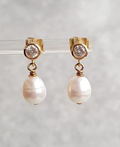 This stunning pair of dangle stud earring. Approximately 8x9mm white freshwater pearls, very good lustre on gold plated stud with cubic zirconia setting.  The earrings is approximately 2cm long The pearls are genuine freshwater pearls therefore each pearl is slightly different in shape, size and each pearl has it own unique natural blemishes The colour of the actual earrings might be slightly different to the photo due to the lighting  All measurement  mentioned in this listing is approximate Mo Anniversary Bridal Earrings With Pearl Drop In Yellow Gold, Anniversary Yellow Gold Bridal Earrings With Pearl Drop, Anniversary Bridal Earrings In Yellow Gold With Pearl Drop, Pearl Pendant Dangle Earrings For Anniversary, Classic High Luster Drop Pearl Earrings, Classic Teardrop Clip-on Pearl Earrings, Anniversary Pearl Charm Dangle Earrings, Anniversary Teardrop Pearl Earrings With High Luster, High Luster Drop Pearl Earrings For Anniversary