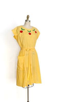 vintage dress  Era: 1950's 1960's Label: Swirl Material: cotton (semi sheer) and appliqué  Closure: back neck button, pull through waist ties Colour: yellow, red, green  Details: super great apple applique along the neckline, classic Swirl wrap construction, fitted bodice with short sleeves, round neckline, nipped pull through waist ties, a-line skirt with a large patch pocket Fits like: medium / large Bust: 42" Waist: 31 - 34" Hips: 50" Length: 40.5" Condition: There is some very minor underarm 1950s Style Cotton Vintage Dress For Summer, 1950s Style Summer Cotton Dress, 1950s Style Cotton Summer Dress, 1950s Summer Cotton Dress, 1950s Style Yellow Vintage Dress For Spring, Mid-century Cotton Summer Dress, Yellow 50’s Dress, 1950s Short Sleeve Cotton Dress, Mid-century Yellow Spring Dresses